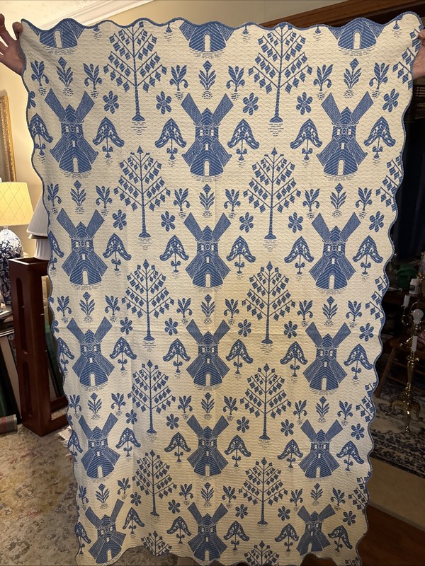 Hand-sewn blue and white textile with windmill and folk art motifs.